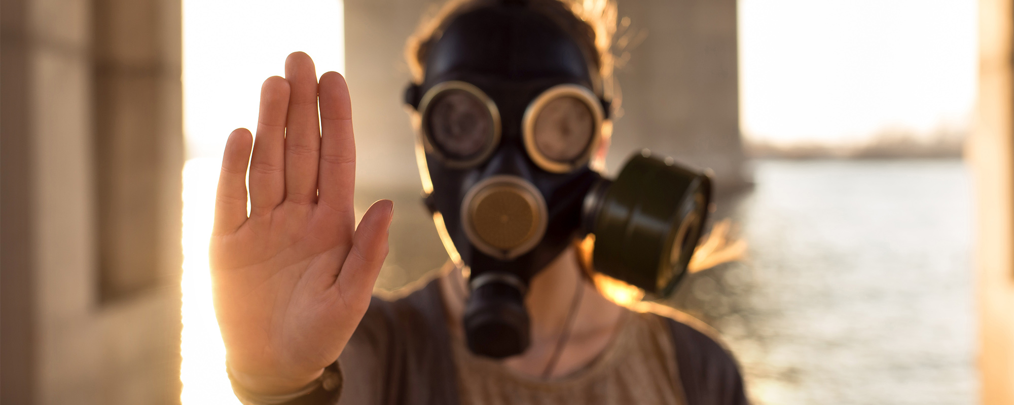 man wearing gas mask hand up