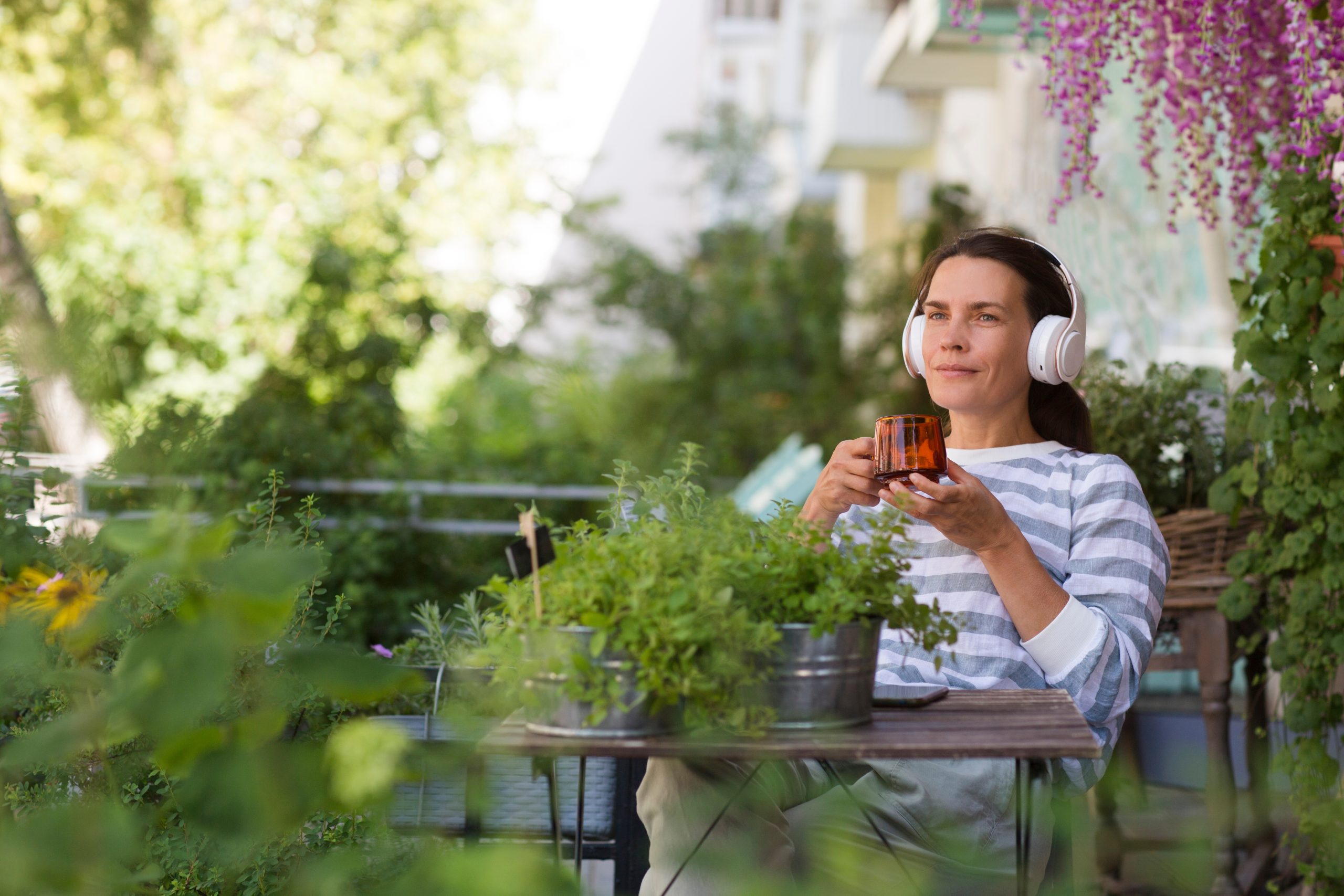 woman listening to podcast in garden, LauraAura Speaker and Mindset Coach, community for women